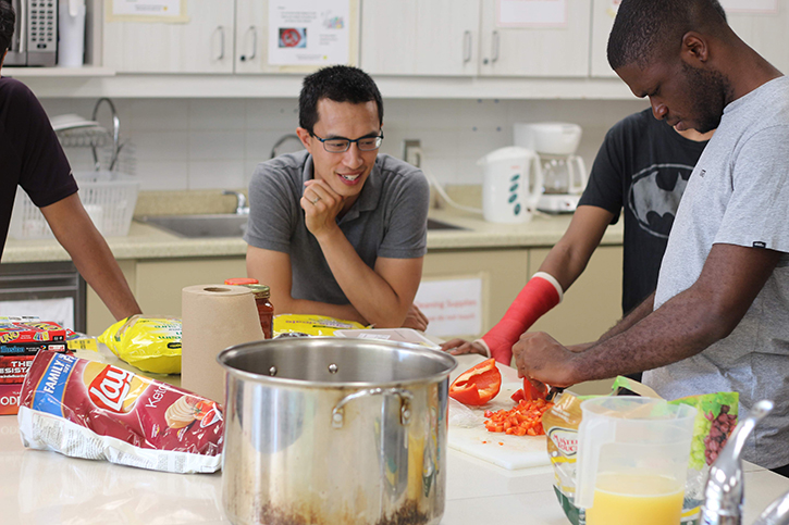 Four men in a kitchen preparing meals